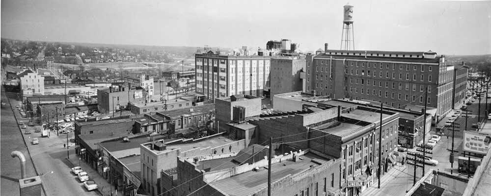 A rooftop view over downtown Winston-Salem toward the tobacco factories and a water tower.
